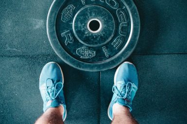 person standing beside black weights